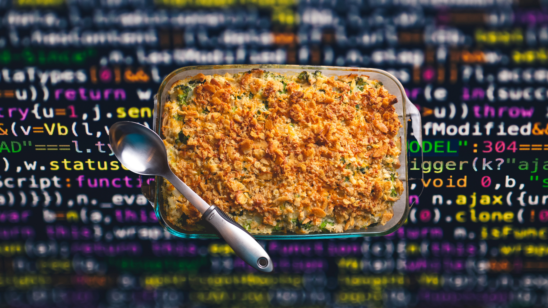 A casserole laid out over a screen full of code.