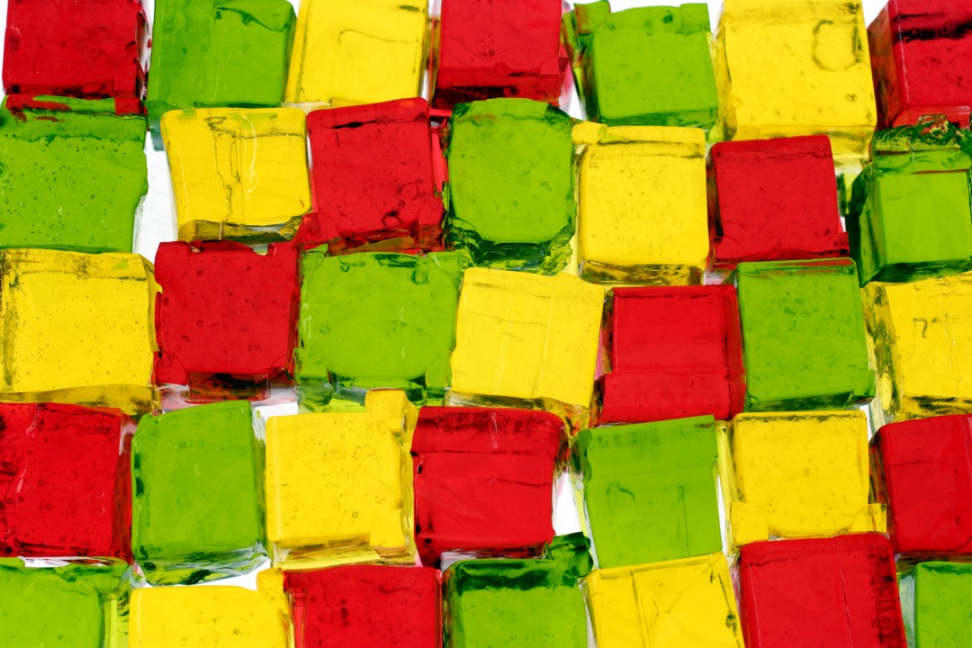 Cubes of red, yellow, and green jello stacked together.