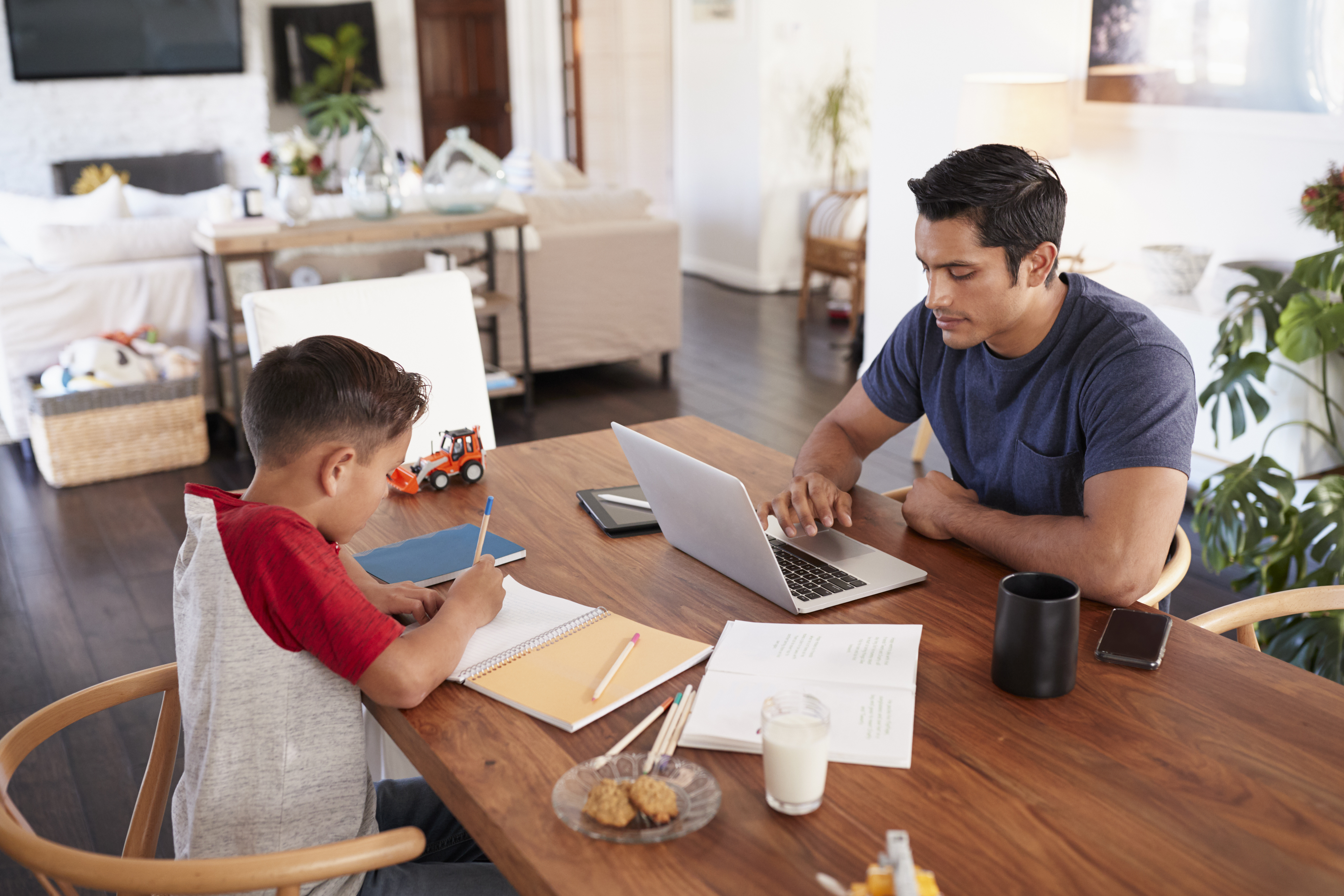 Dad and son working together at a table.